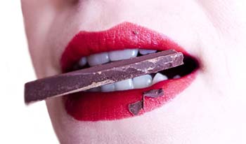 A woman enjoying a piece of chocolate A woman enjoying a piece of chocolate